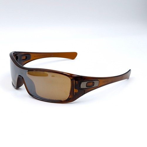 542 - A pair of Oakley wrap around sunglasses with gold tinted frames. Lenses clear.