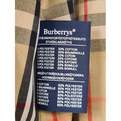 790 - Star lot : A Burberry's of London designer men's trench coat with belt and classic check lining. Ver... 