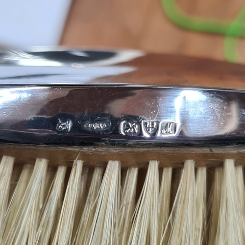 822 - A lot of three sterling silver case brushes including two hair brushes and one clothes brush. All ha... 