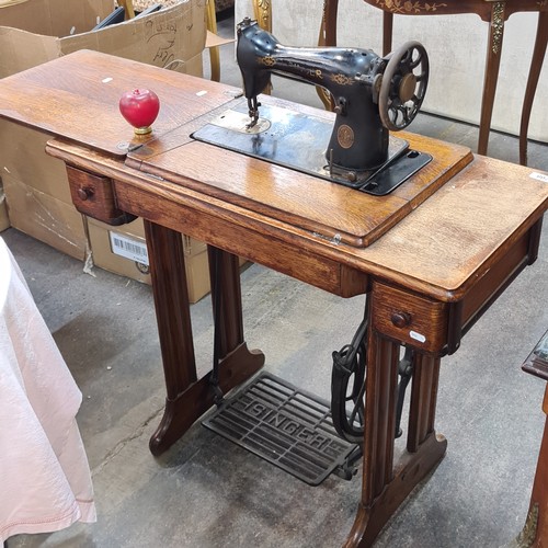 708 - A wonderful antique Singer sewing machine complete with work table and drawers.