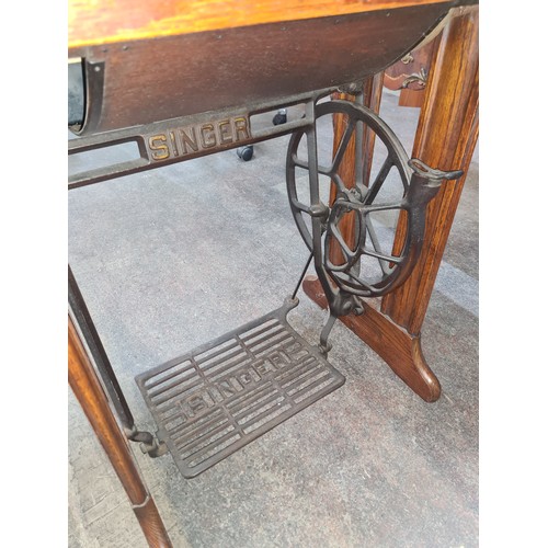 708 - A wonderful antique Singer sewing machine complete with work table and drawers.