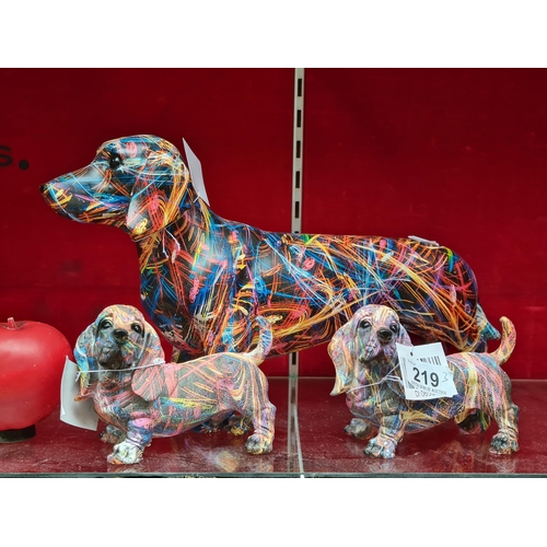 219 - Three funky dog figures including one large Dachshund example and two miniature Basset hound example... 