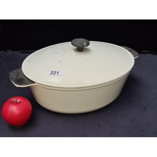 221 - An excellent example of a very large cast iron lidded casserole dish in an off white finish. Stamped... 