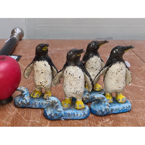 269 - Four vintage heavy cast iron penguin figurines.