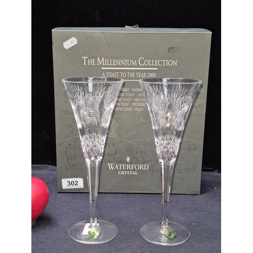 302 - A stunning pair of Waterford Crystal champagne flutes from the Millennium Collection. In excellent c... 