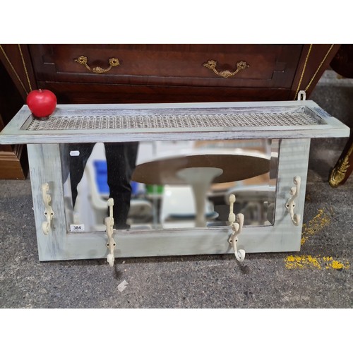 384 - Star Lot : A shabby chic hall bevelled mirror featuring four metal coat hooks and a wicker shelf to ... 