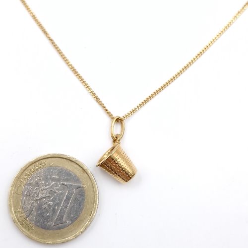 18 - Star Lot : An 18ct gold 750 carat gold pendant & chain. Pendant in the form of a thimble. Length - 4... 