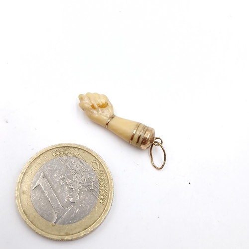 41 - An unusual pendant/charm in the form of a clenched hand. Length - 2.5 cms.