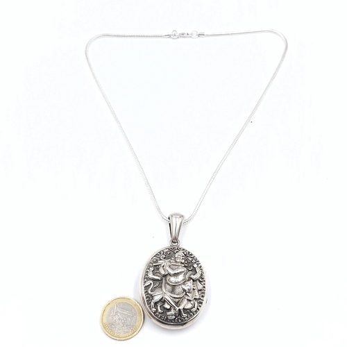 431 - A fabulous sterling  silver locket pendant with repousse embossing to depict Krishna playing the flu... 