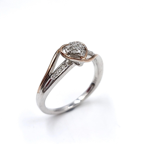 439 - A diamond ring in the form of a heart with a nine carat gold mount set with diamond shoulders. Ring ... 