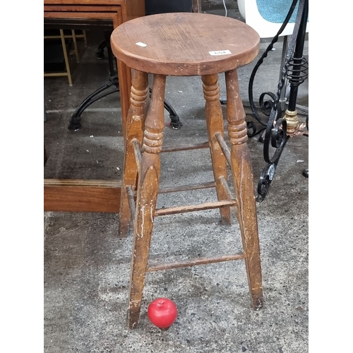 654 - Rustic wooden stool with turned legs and circular seat. Solid construction with natural wood grain f... 