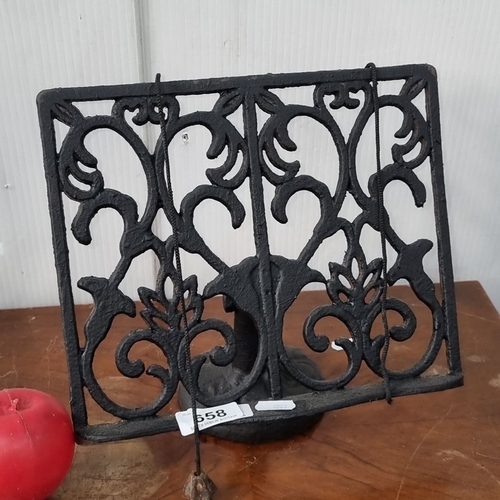 658 - Ornate cast iron book stand with intricate Victorian-style scrollwork.