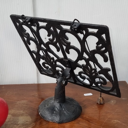 658 - Ornate cast iron book stand with intricate Victorian-style scrollwork.