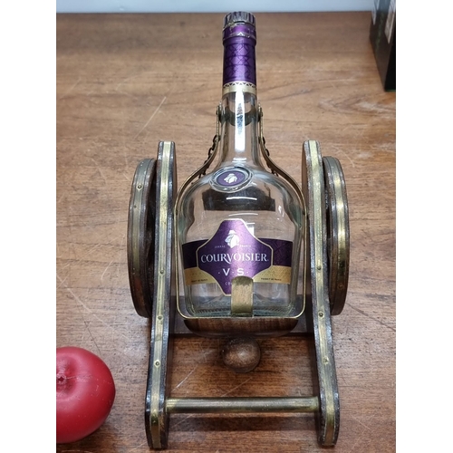 675 - An empyt Courvoisier Cognac bottle in a wooden cannon decanter holder. Accompanied by a boxed set of... 