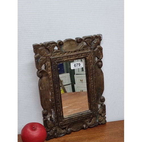 679 - Ornate carved wooden mirror  with leaf and scroll motifs, featuring a rectangular mirror insert. Bac... 