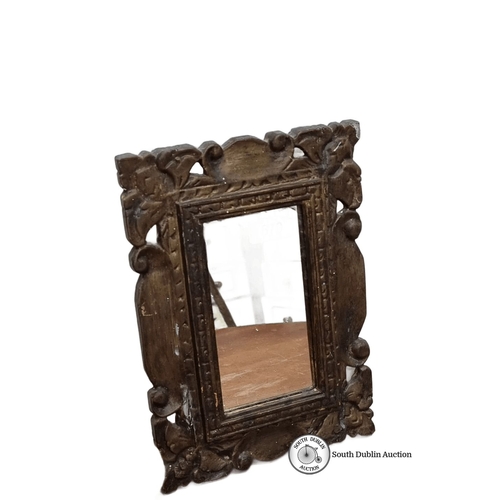 679 - Ornate carved wooden mirror  with leaf and scroll motifs, featuring a rectangular mirror insert. Bac... 