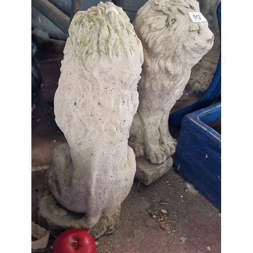 912 - A Pair of stone lion garden statues, showing intricate detailing and weathered patina.