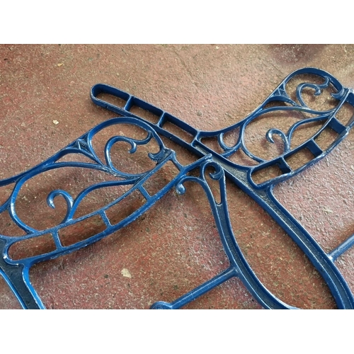 914 - Pair of ornate blue cast iron bench ends featuring scrollwork design.