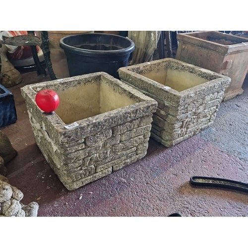 916 - A Pair of vintage stone planters with a rustic rock-faced design.