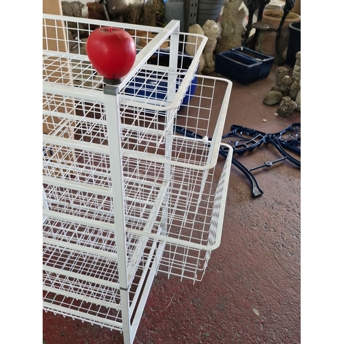 917 - A White metal storage rack with five wire mesh shelves.