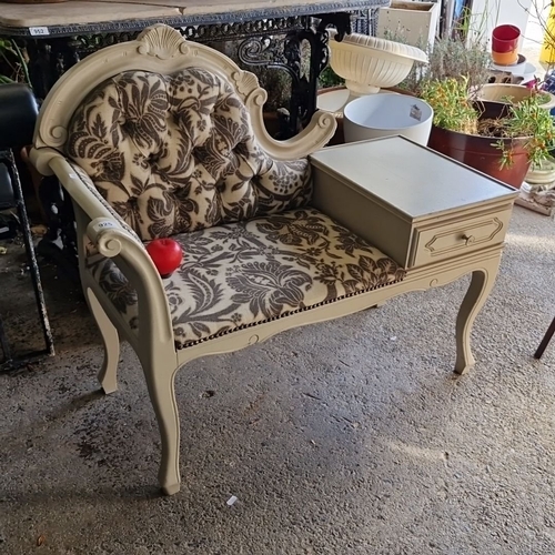 925 - A vintage telephone bench features ornate carved wood, curvilinear lines, and floral-pattern upholst... 