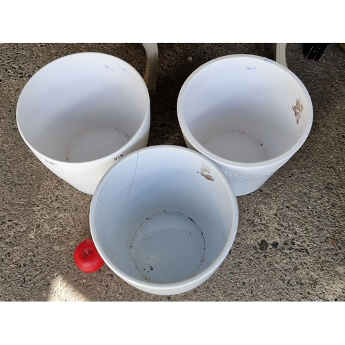 930 - Set of three white plastic plant pots with varied textures.