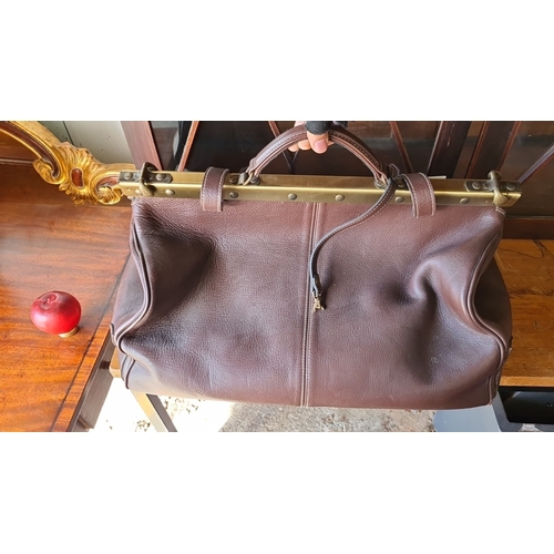 941 - A Vintage brown leather gladstone  bag with brass frame and linen interior. Features zippered pocket... 