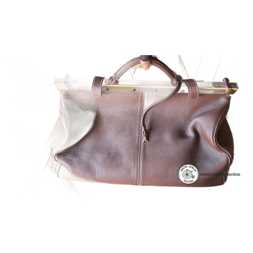 941 - A Vintage brown leather gladstone  bag with brass frame and linen interior. Features zippered pocket... 