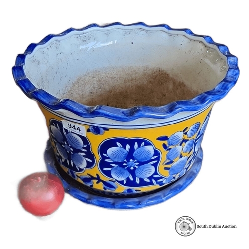 944 - A Hand-painted ceramic planter with floral blue and yellow design, accompanied by a matching base tr... 