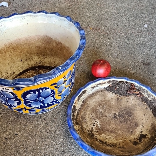 944 - A Hand-painted ceramic planter with floral blue and yellow design, accompanied by a matching base tr... 