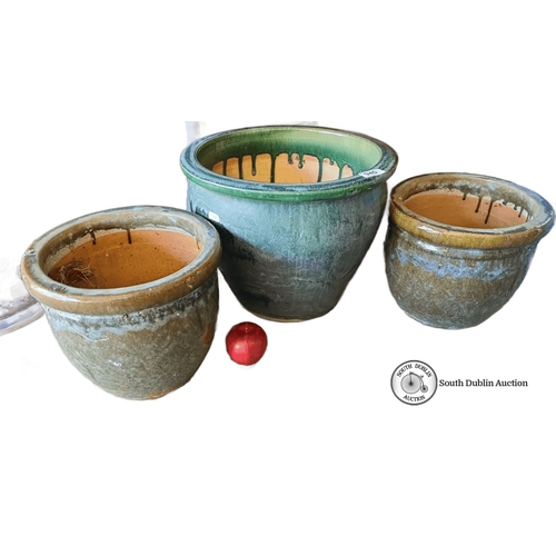 945 - A Set of three glazed ceramic planters, featuring earthy green tones and a rustic drip effect.