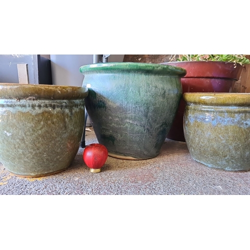 945 - A Set of three glazed ceramic planters, featuring earthy green tones and a rustic drip effect.