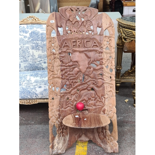 393 - A magnificent profusely hand-carved African birthing chair. Boasting animal motifs with elephant and... 