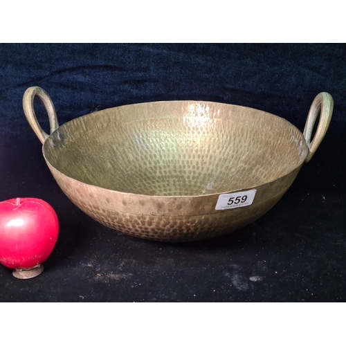 559 - A traditional large vintage pure brass twin handled asian cooking pot.