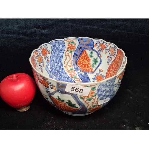 568 - An antique Japanese porcelain Imari bowl with ribbed body and scalloped edging. Wonderfully hand pai... 