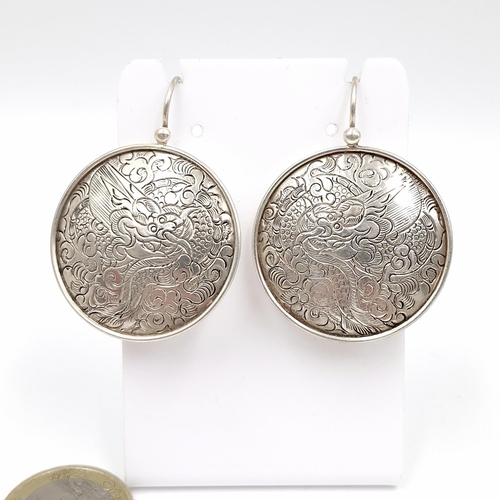 636 - A beautiful pair of Nepalese sterling silver earrings featuring a very detailed etched dragon design... 