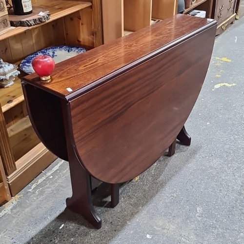 1030 - A Victorian mahogany drop-leaf gateleg table with oval top and supporting legs. Folds compactly.