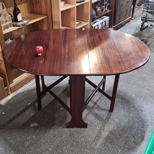 1030 - A Victorian mahogany drop-leaf gateleg table with oval top and supporting legs. Folds compactly.