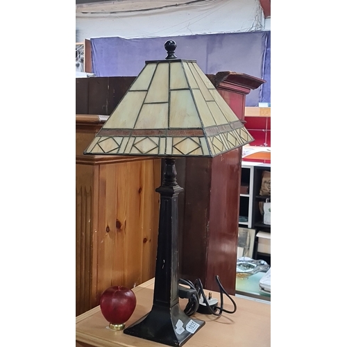 1035 - An Art Deco-inspired table lamp featuring a stained glass shade with geometric pattern and black met... 