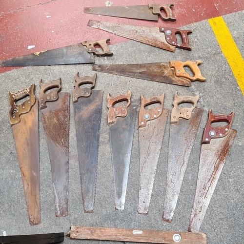 1063 - Lot of 11 vintage hand saws with wooden handles, featuring a Spear & Jackson saw.