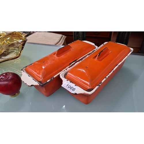 1066 - Pair of vintage orange enamelware bread loaf pans with lids, showcasing the distinct chipping often ... 