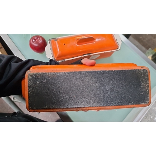 1066 - Pair of vintage orange enamelware bread loaf pans with lids, showcasing the distinct chipping often ... 