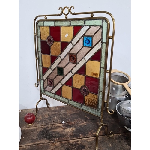 972 - Star lot :A Brass-framed stained glass fire screen, featuring a geometric pattern with squares and f... 