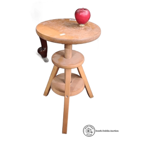 974 - A Wooden adjustable-height potters stool with screw mechanism and three legs. Light-colored finish, ... 