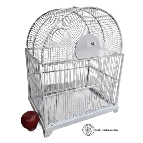 978 - White-painted metal birdcage with an arched top, featuring intersecting wire bars and a door on one ... 