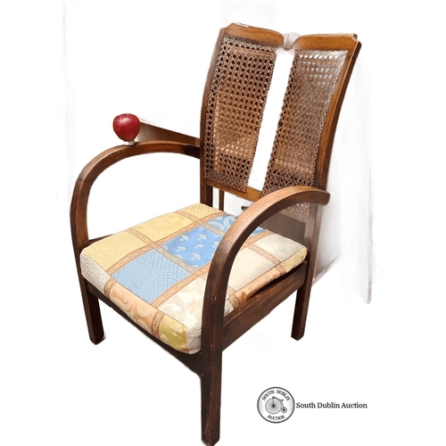 980 - Vintage wooden armchair with woven cane backrest and patterned fabric cushion. The chair includes cu... 