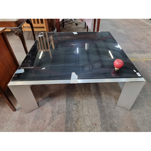 1175 - A sleek and stylish metal framed square coffee table with black glass topped surface.

Previously in... 