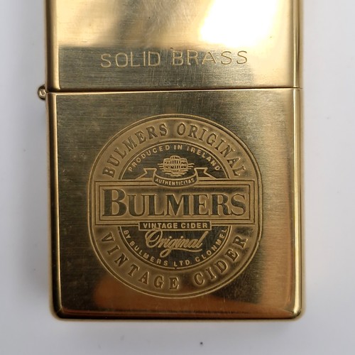 1002 - Three Zippo lighters including a Marlboro example and a Bulmer's solid brass example.