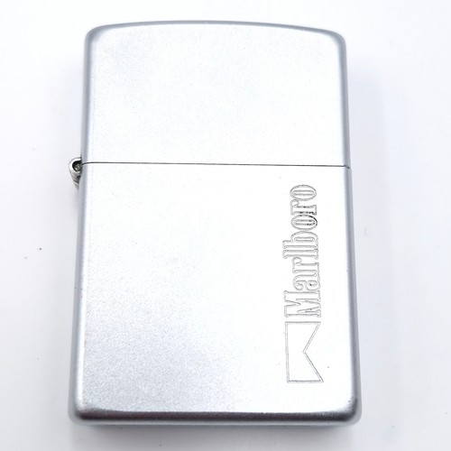 1002 - Three Zippo lighters including a Marlboro example and a Bulmer's solid brass example.