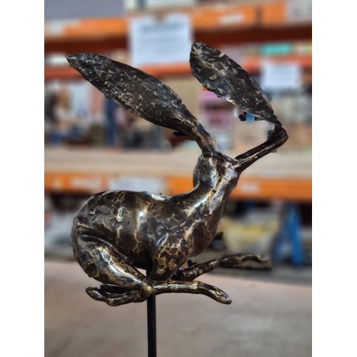 158 - Star Lot : A large intricate bronze sculpture depicting a whimsical hare in mid-leap, showcasing exq... 